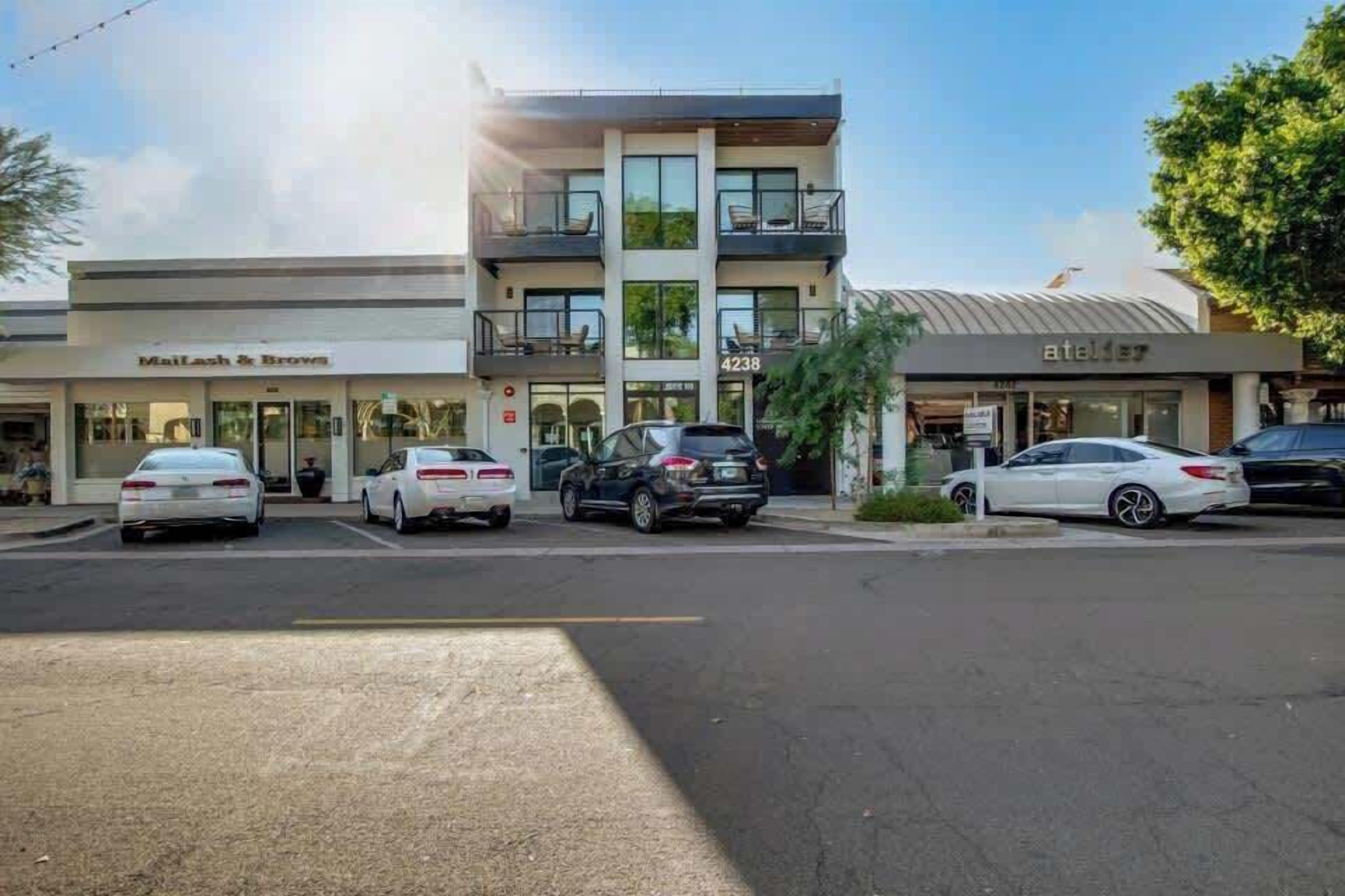 Um edifício de vários andares com uma loja no térreo chamada 'Mailish & Browne' e outra loja no segundo andar chamada 'Atelier'.