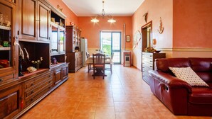 A spacious living room with a fireplace, a dining area, and a kitchen with wooden cabinets.