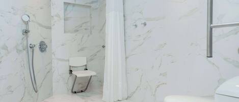 A bathroom with a shower, toilet, and a small sink.