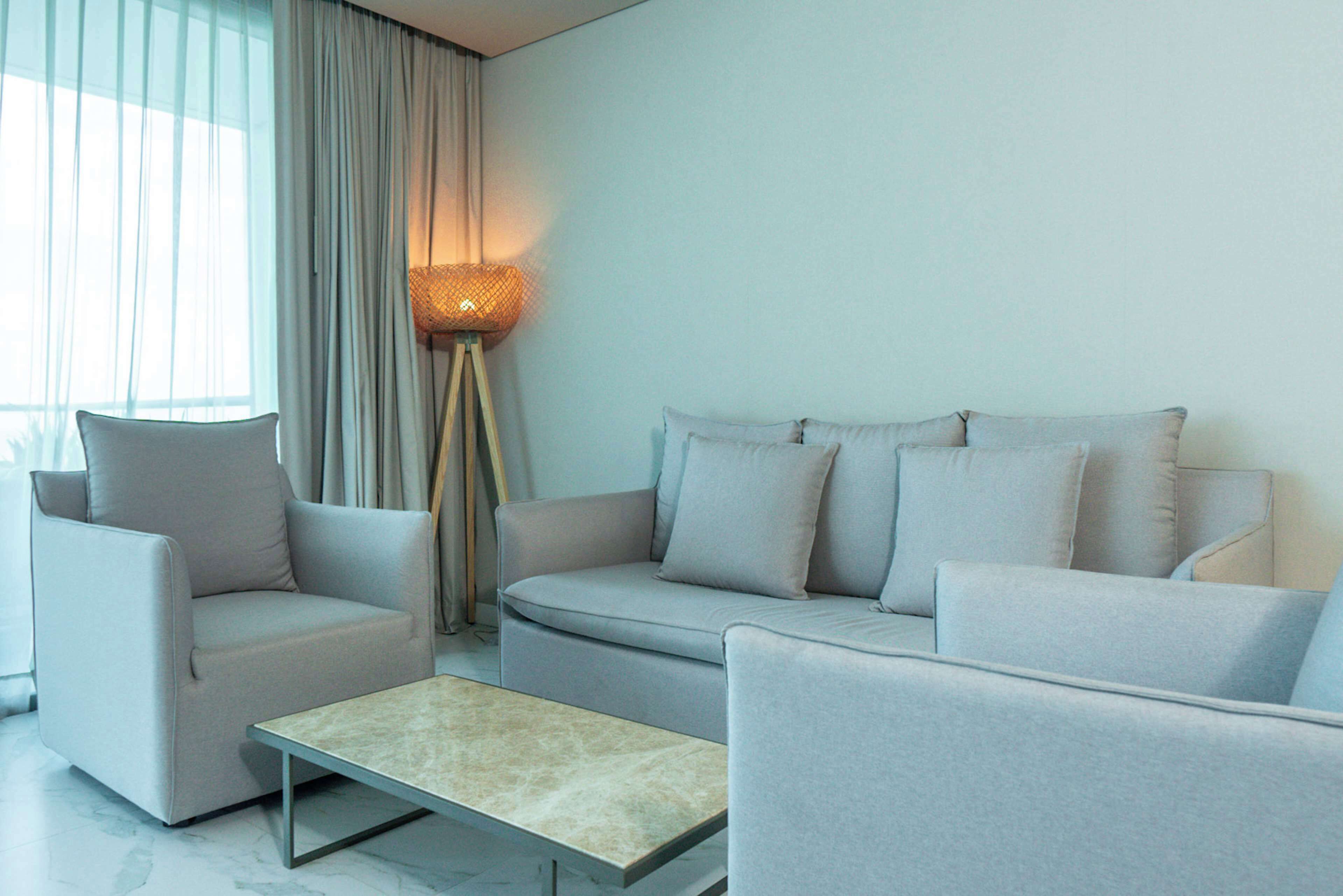A modern living room with a sofa set, a coffee table, and a floor lamp.