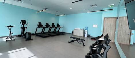 A spacious gym with treadmills, an elliptical, and a bench press.