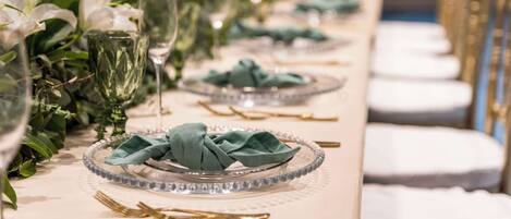 A table set with clear glassware, green napkins, and white flowers.