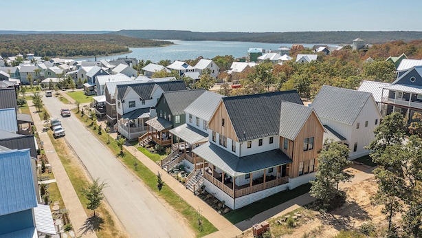 Un quartier résidentiel où l’on trouve des maisons dotées de toits à pignons et une maison en bois remarquable, avec un porche.