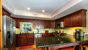 Una cocina moderna con armarios de madera oscura, electrodomésticos de acero inoxidable y encimera de granito.