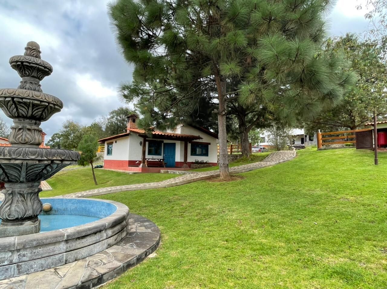 Una casa con una fuente en el jardín delantero.