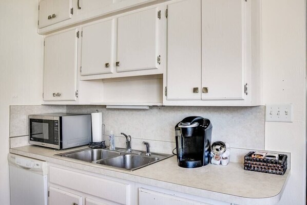 A compact kitchen with white cabinets, a microwave, a coffee maker, and a sink. - Perfect Notre Dame Weekend Home, 0.8 Miles to ND! (South Bend)