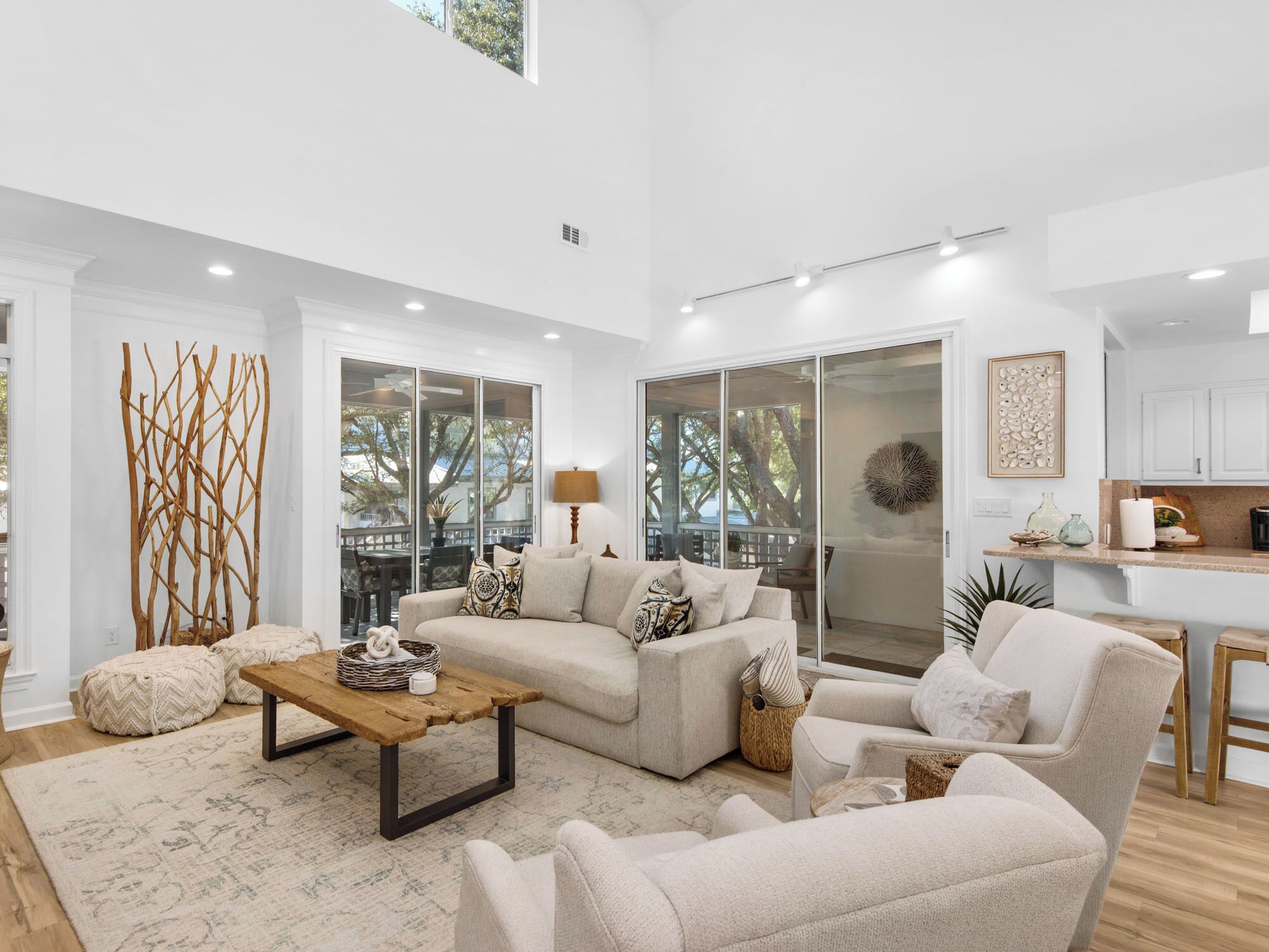 A spacious living room with a large sofa, a coffee table, and a view of the outdoors through sliding glass doors.
