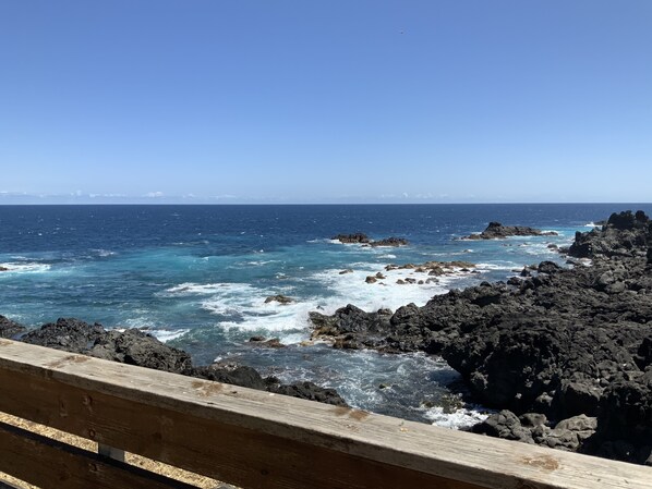 A coastal view with rocky terrain and the ocean.