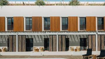Um edifício moderno com piscina, ripas de madeira e mobiliário de vime.
