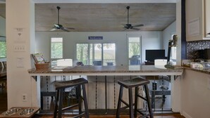A kitchen with a bar area, wooden ceiling, and a 'Welcome' sign. - Large private home | Hot tub | Mins to SDC (Branson West)