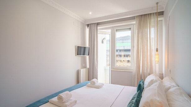 A hotel room with a bed, a TV, and a window with curtains. - Feel Porto Downtown Charming Apartment II (Porto)