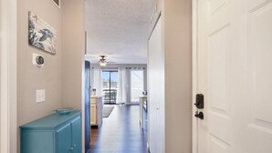 A hallway with a ceiling fan, a view to a balcony, and a door on the right. - Turtle Haven - Relax & Enjoy the Incredible Views! (Osage Beach)