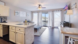 A spacious living area with a kitchen, a dining area, and a balcony with a view. - Turtle Haven - Relax & Enjoy the Incredible Views! (Osage Beach)