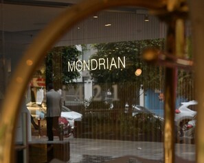 Une vue à travers une fenêtre sur laquelle on peut lire le mot « MONDRIAN ».