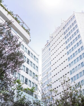 Un moderno edificio de gran altura con fachada de vidrio y varios balcones.