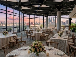 A rooftop dining area with tables set for a meal, large windows offering a city view, and a modern architectural design. - Mondrian Mexico City Condesa  (Mexico City)