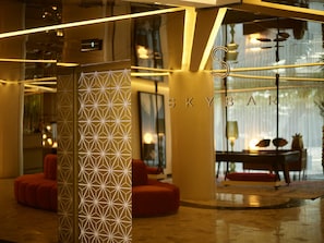 Relax in a stylish space with a geometric patterned partition, seating area, and dining table.
