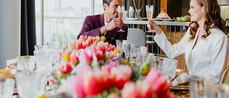 Ein Esstisch mit Tulpen, klaren Gläsern und Blick auf die Stadt.