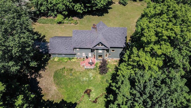 A two-story house with a dark roof, surrounded by dense green trees. - Bridgewalk Estate | a Wanderlust Abodes property (Central Lake)