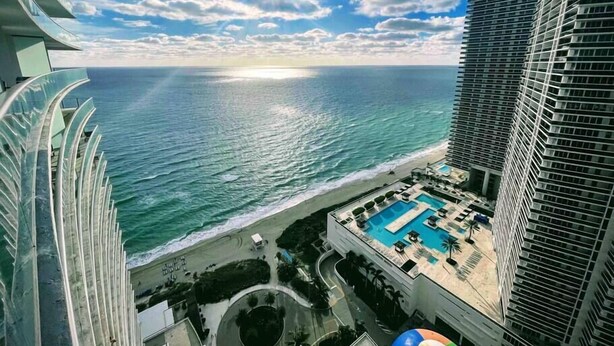A high-rise hotel with a rooftop pool, ocean view, and a circular driveway. - Amazing Ocean Views at LYFE Resort @rent4us (Hollywood)