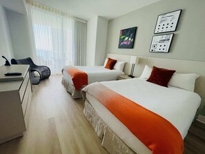 Une chambre d’hôtel avec deux lits, un bureau et une chaise.