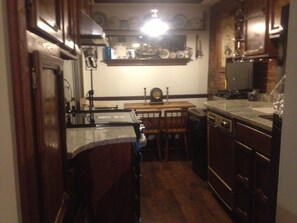 Compact kitchen with sink, stove, and dining area.
