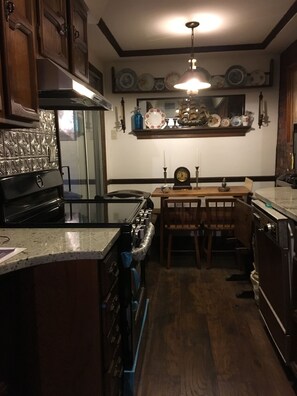Enjoy cooking in this well-equipped kitchen with a central island, oven, and stainless steel range hood.