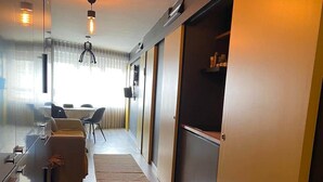Een modern interieur met keuken, eethoek en gang naar een slaapkamer.