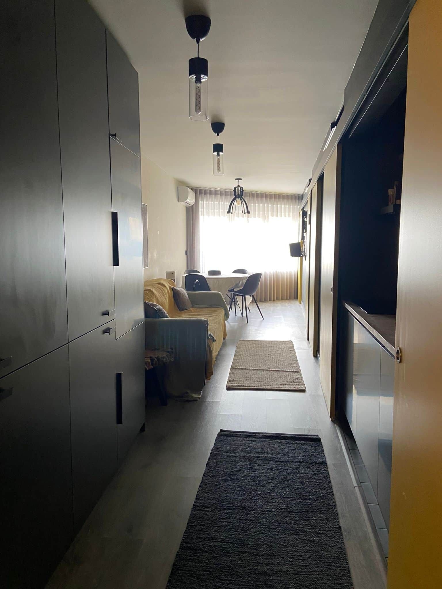 Un interior moderno con kitchenette, comedor y sofá.