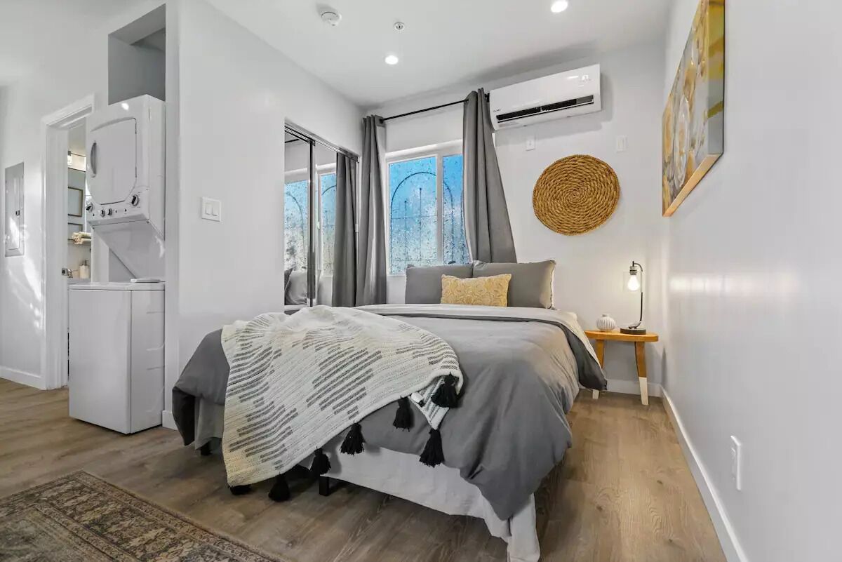 Een moderne slaapkamer met een bed, nachtkastje en een klein bureau.