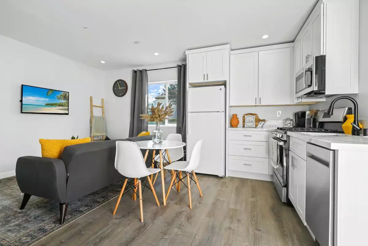 A modern kitchen with white cabinets, a built-in oven, and a microwave.