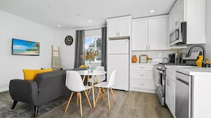 A modern kitchen with white cabinets, a built-in oven, and a microwave. - Adorable studio close to DTLA (Alhambra)