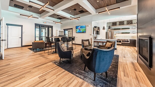 A modern interior with wooden flooring, a TV mounted on the wall, and a kitchen area with built-in appliances. - Beautiful chic modern one bedroom (Colorado Springs)