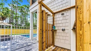 A wooden door with a small window, a pool, and a wooden deck.