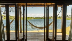 Un pontile in legno con un'amaca e vista su un lago.