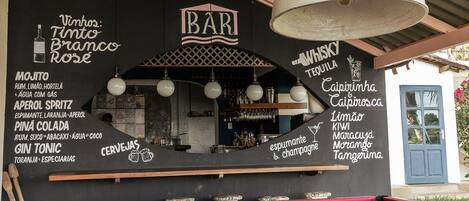 Eine Bar mit Billardtisch, Stehtischen und einer Kreidetafel, auf der Getränke angeboten werden.