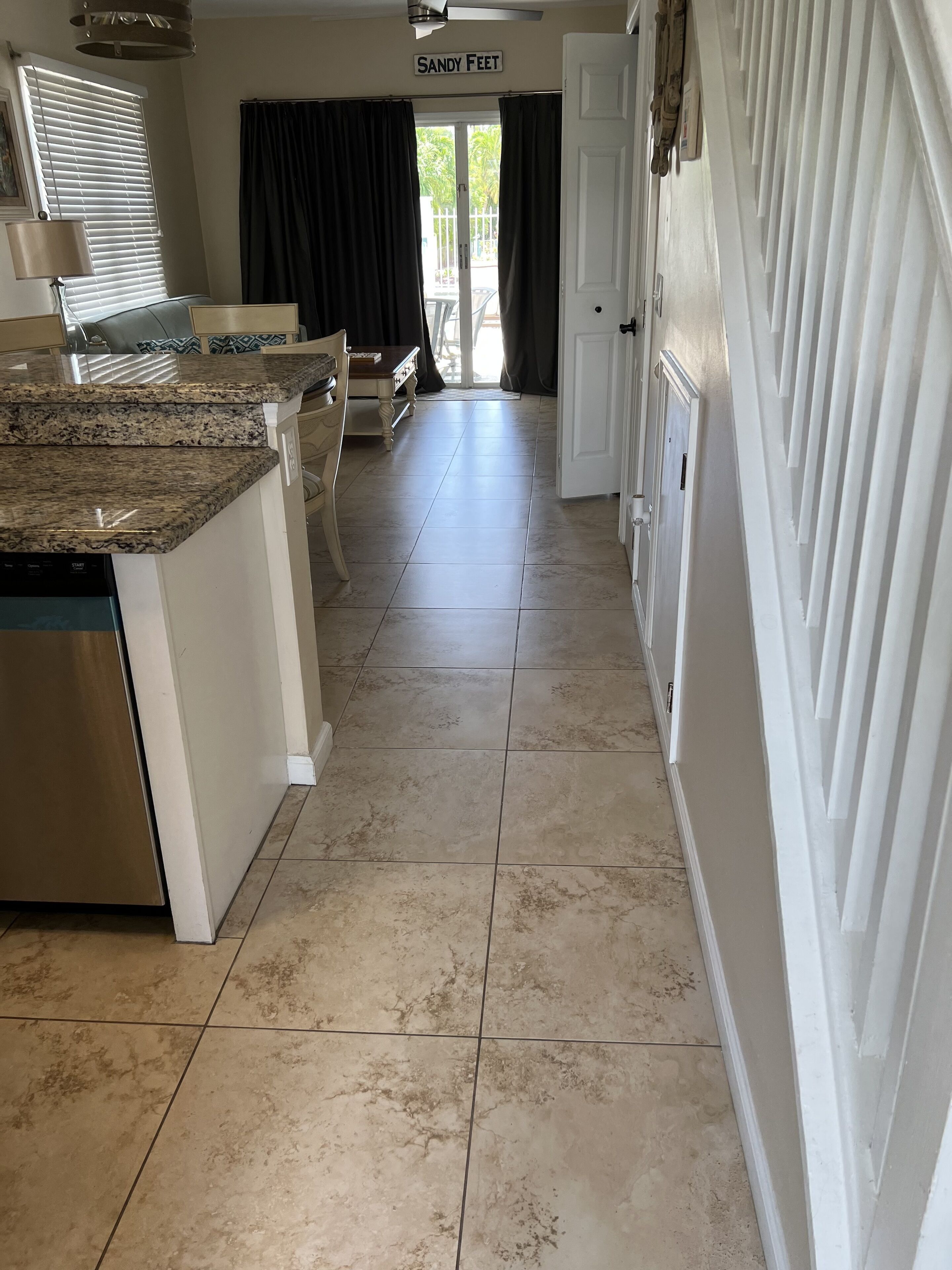 A kitchen with a granite countertop, a dishwasher, and a dining area with a table and chairs.