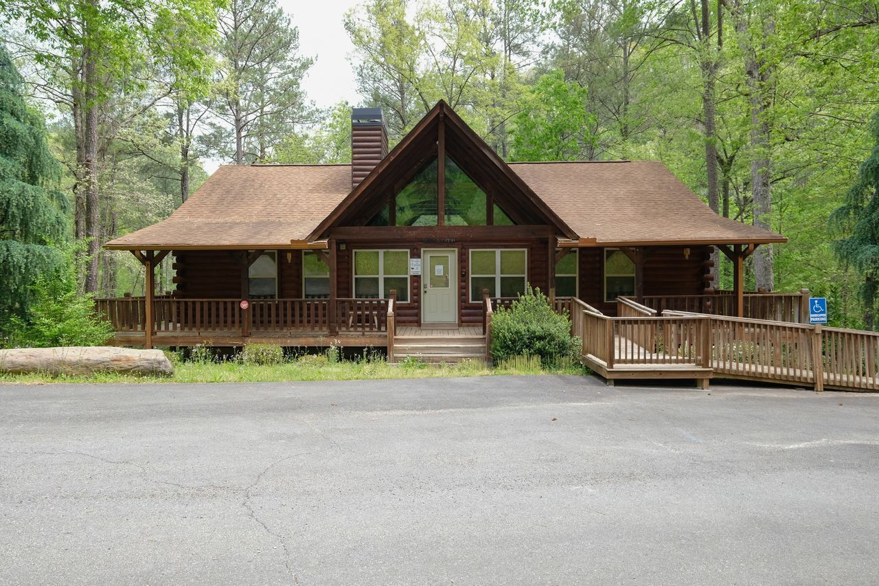 A lodge with a wooden exterior, a front porch, and a staircase leading to the entrance.