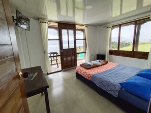 A bedroom with a bed, a desk, and a view of the outdoors. - Hotel Tota Eliseo Playa Blanca (Tota)
