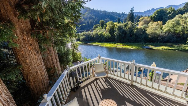 Une terrasse avec vue sur une rivière et une forêt.