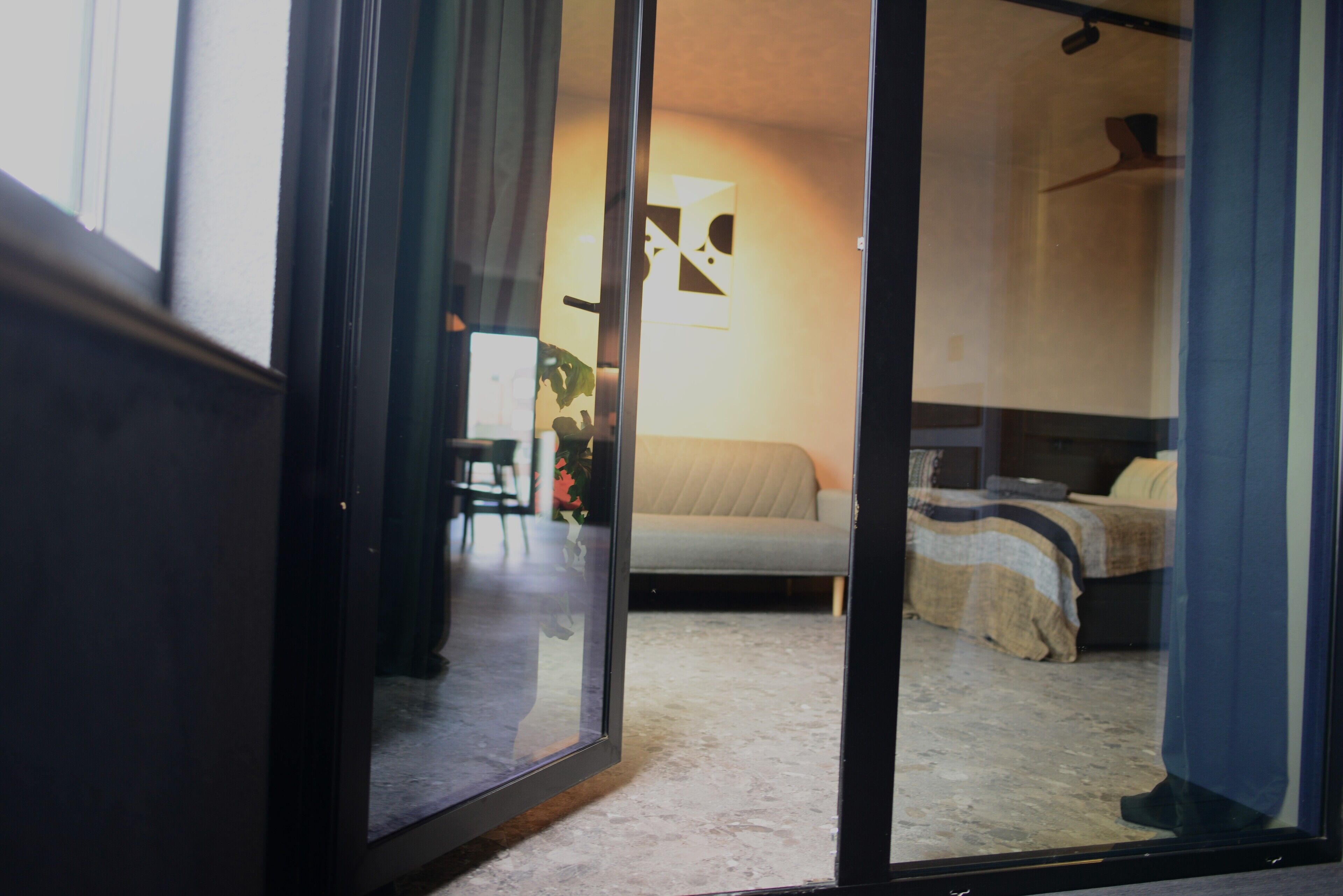 A bedroom with a bed, a nightstand, and a window with curtains.