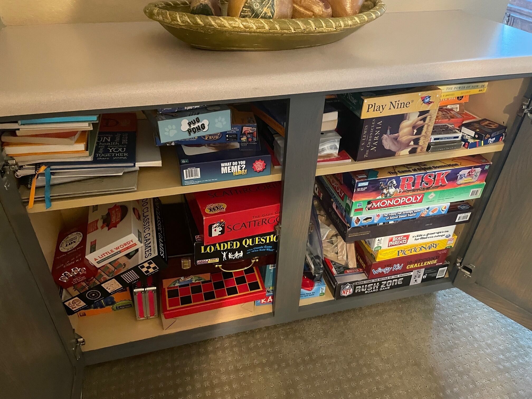 Een kast met verschillende bordspellen en boeken.
