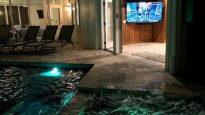 Zona de piscina con fuente de agua y una pantalla de televisión al fondo.