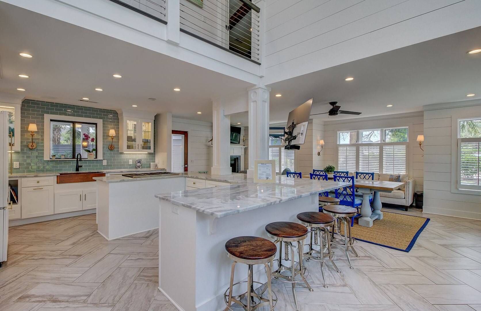 A spacious kitchen with a large island, bar stools, and a dining area with a table and chairs.