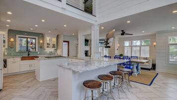 A spacious kitchen with a large island, bar stools, and a dining area with a table and chairs.