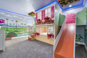 A playroom with a slide, a mural of a landscape, and a staircase. - Private Pool with Spillover Spa | Built-in BBQ | Kids Themed Bedrooms (Kissimmee)