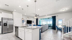 A modern kitchen with white cabinets, a stainless steel refrigerator, and a built-in dishwasher.