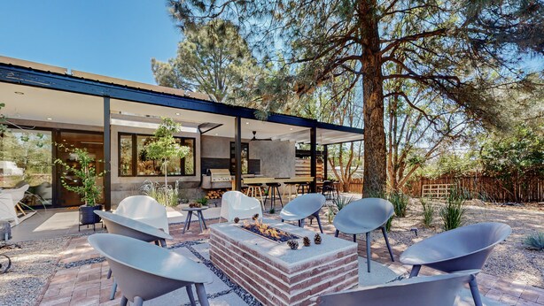 A modern outdoor patio with a fire pit, seating, and a view of the house. - Modern Maison in the middle of Santa Fe (Santa Fe)