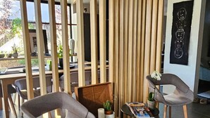 A modern interior with two grey upholstered chairs, a wooden coffee table, and a vertical wooden partition. - Modern Maison in the middle of Santa Fe (Santa Fe)