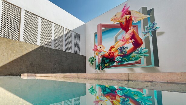Un edificio moderno con un mural de peces y plantas coloridos.